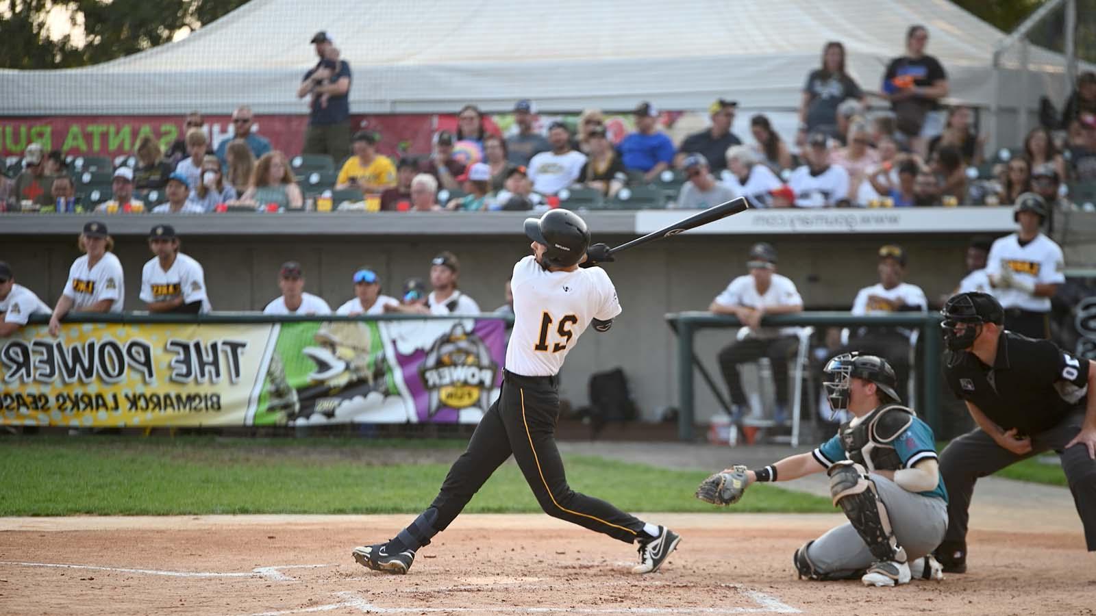 Crowded baseball game with batter in full swing