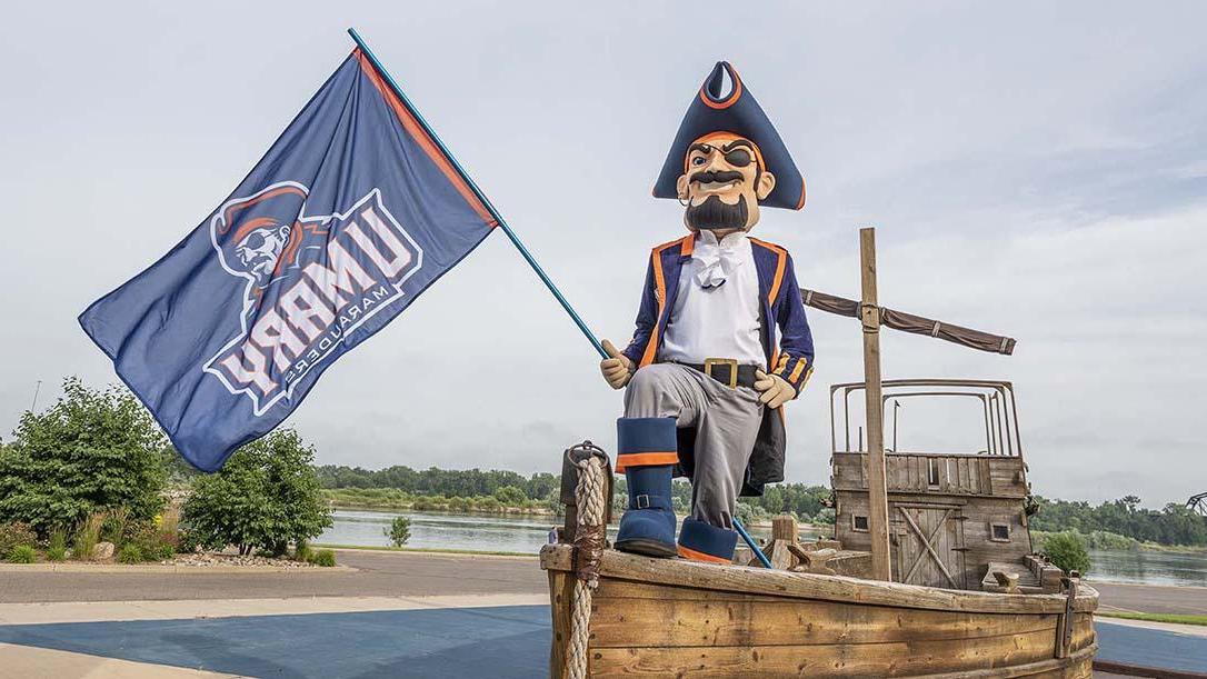 Max the Marauder standing on the front of a boat with a Marauders flag 